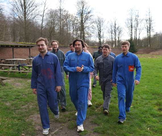 Groupe de joueurs de paintball en combinaisons bleues marchant ensemble vers le terrain de jeu en plein air à Wavre
